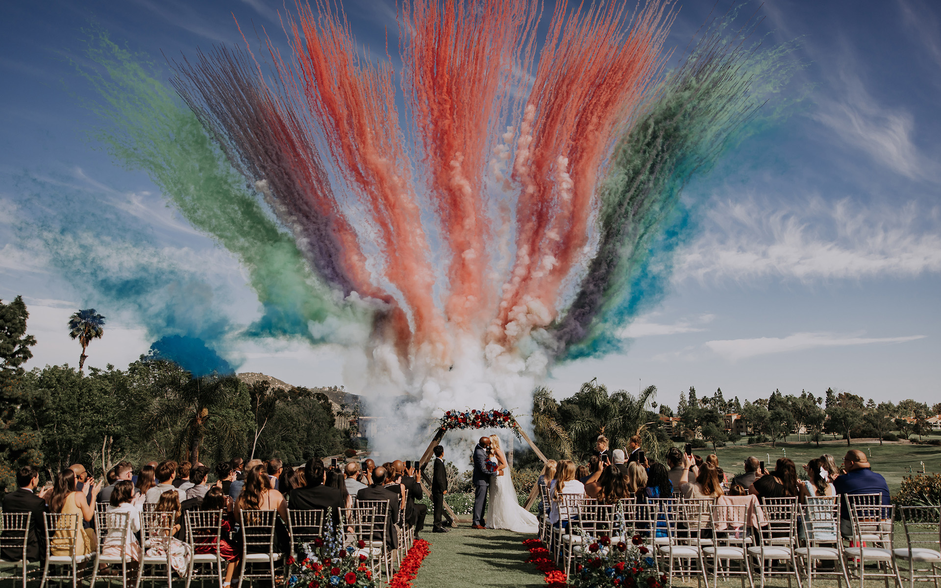 Multicolored smoke in background of a wedding ceremony on a golf course